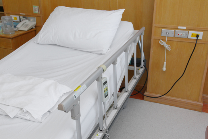 Bettgalgen mit Dreieckgriff als Aufstehhilfe neben Krankenbett