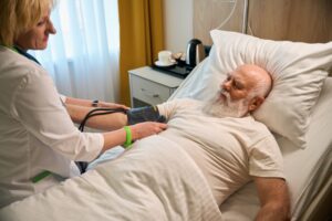 Das Foto zeigt eine ältere, bettlägrige Person in der Intensivpflege.