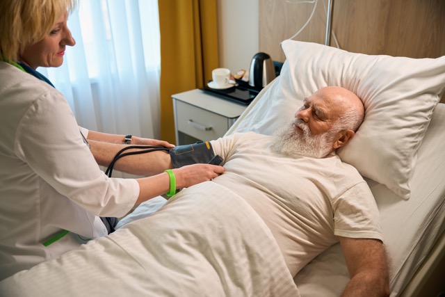 Das Foto zeigt eine ältere, bettlägrige Person in der Intensivpflege.